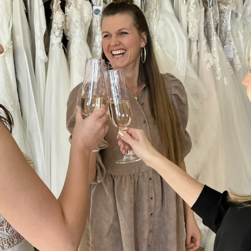 Andrea stößt mit Sekt auf das gefundene Kleid an